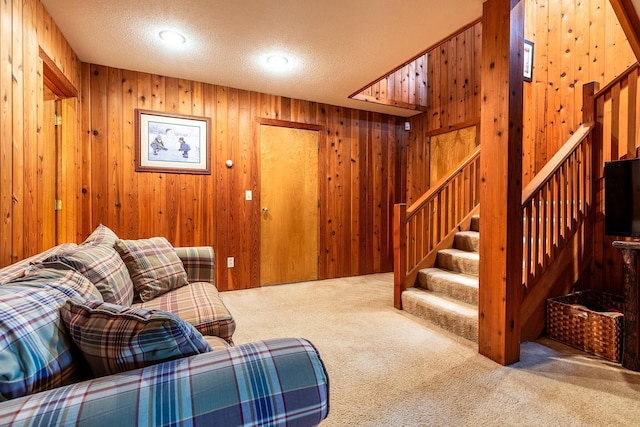 living room with wood walls, carpet floors, and a textured ceiling