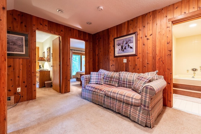 carpeted living room with wood walls