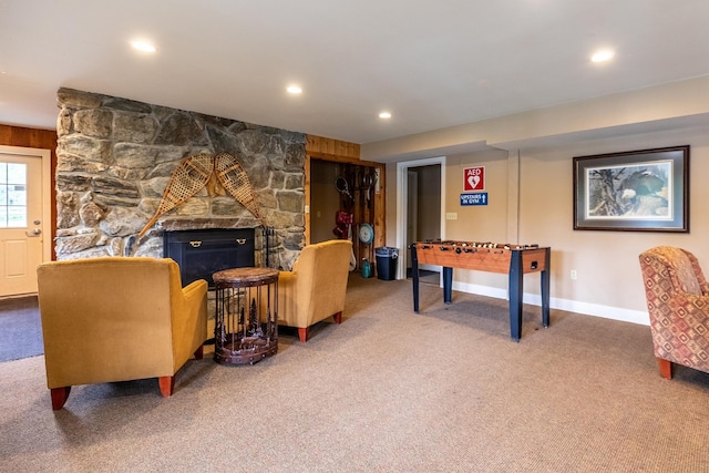 recreation room featuring carpet flooring, wood walls, and a fireplace