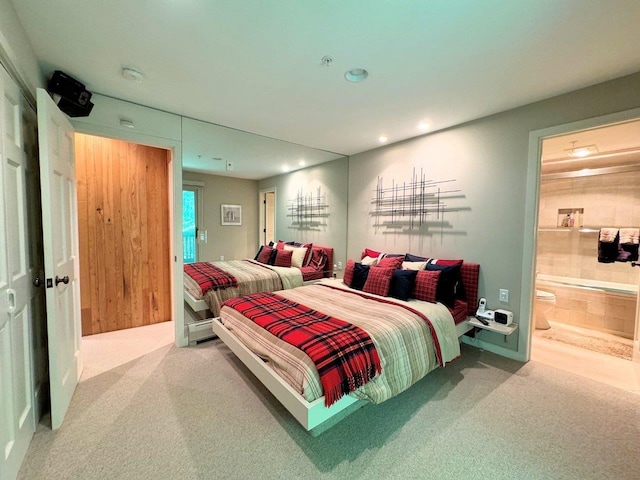 bedroom with ensuite bath and carpet flooring