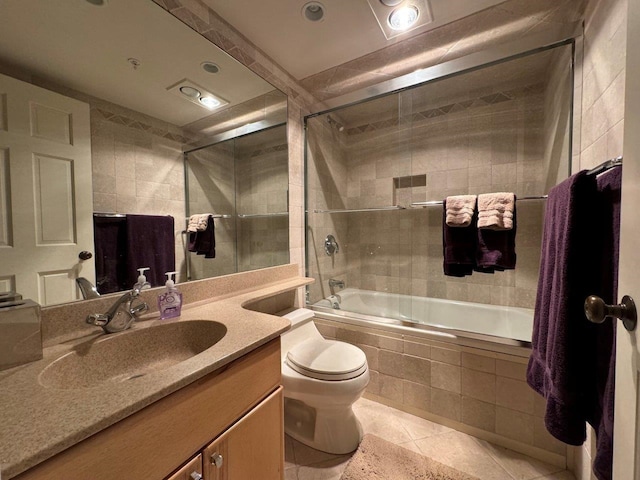 full bathroom featuring enclosed tub / shower combo, tile patterned floors, toilet, and vanity