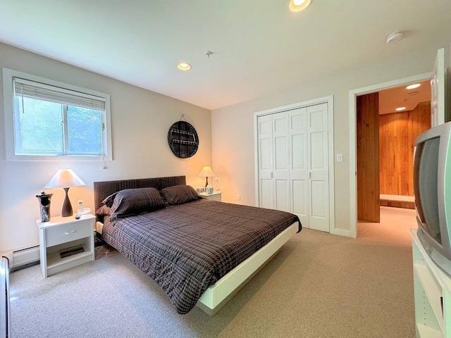 carpeted bedroom featuring a baseboard radiator and a closet