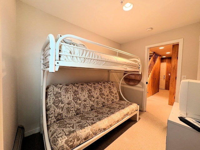 bedroom with light colored carpet and a baseboard heating unit