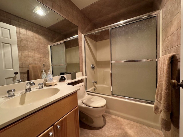 full bathroom featuring vanity, tile patterned floors, toilet, and combined bath / shower with glass door