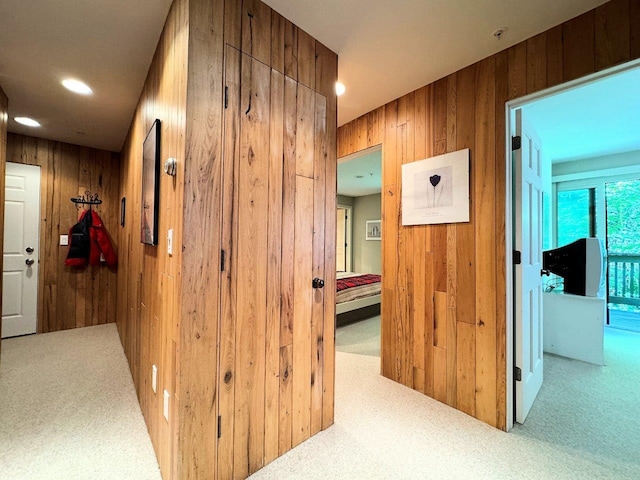 hall featuring wooden walls and carpet flooring