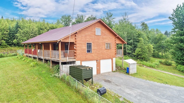 exterior space featuring a porch, a garage, and a yard