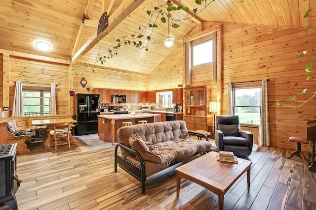 living room with a wealth of natural light, wood ceiling, wooden walls, and light hardwood / wood-style flooring