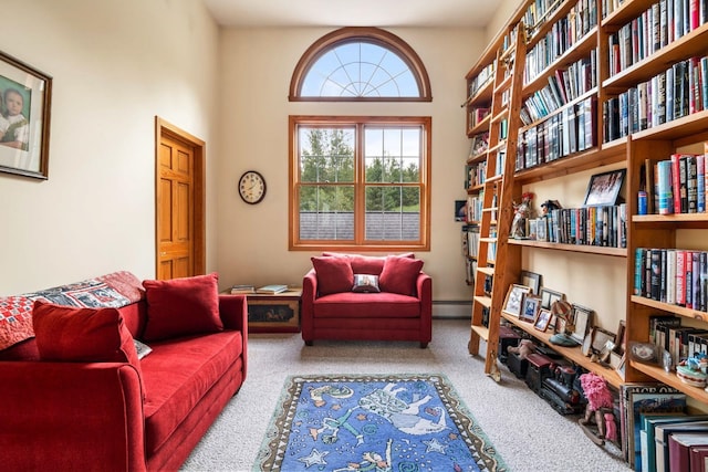 living area with carpet, a towering ceiling, and baseboard heating