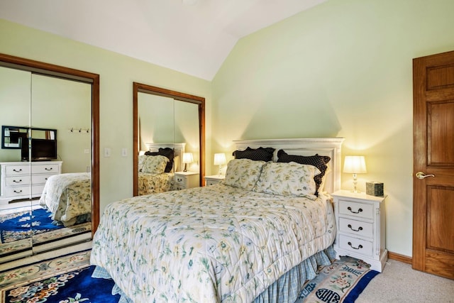 bedroom featuring light colored carpet and lofted ceiling