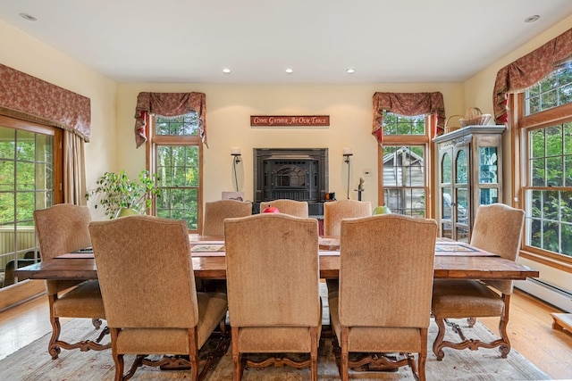 dining space featuring wood-type flooring and a wood stove