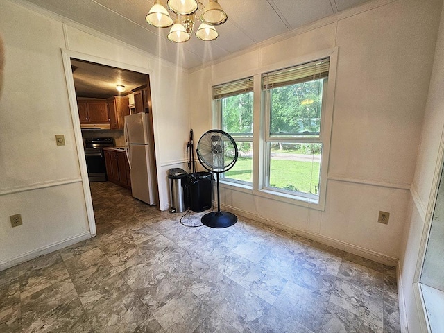 unfurnished dining area with baseboards and a chandelier