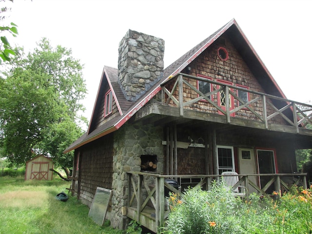 back of house with a storage shed