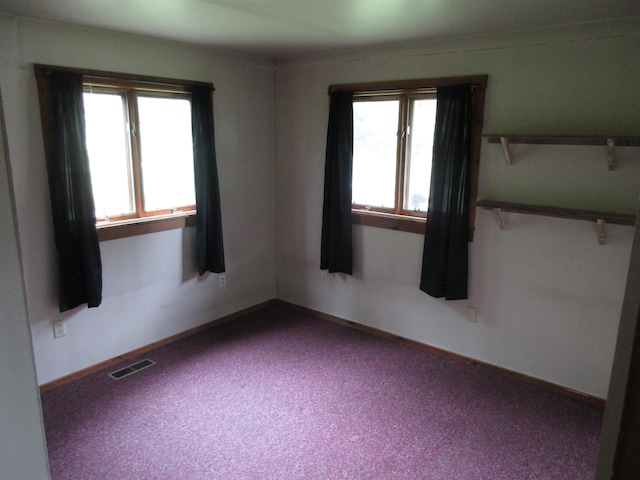 spare room with baseboards, carpet, and visible vents