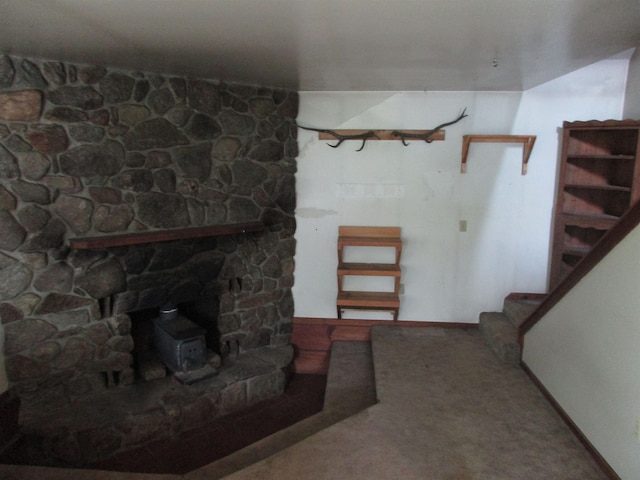 below grade area featuring baseboards, carpet, and stairs