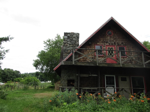 rear view of house with a chimney and a balcony