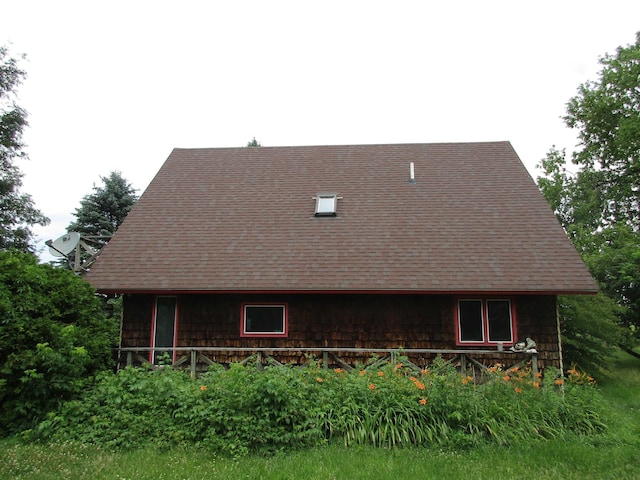 rear view of property featuring a shingled roof