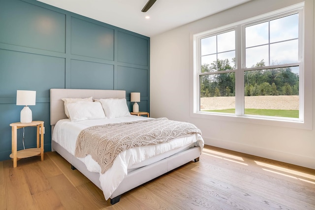 bedroom with light hardwood / wood-style floors and ceiling fan