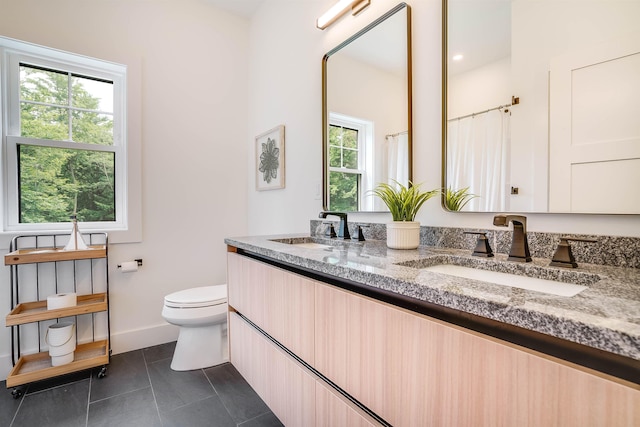 bathroom featuring tile patterned floors, toilet, vanity, and plenty of natural light