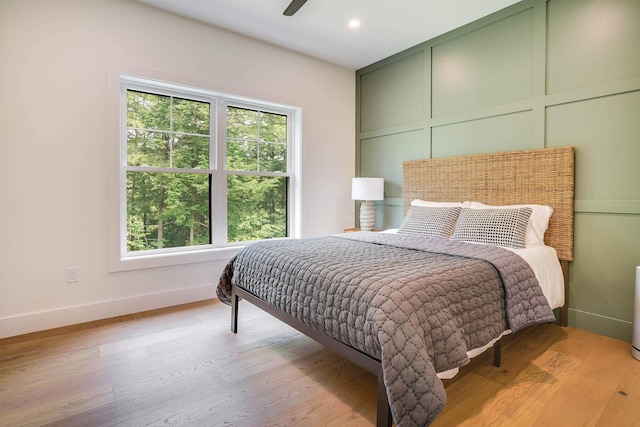 bedroom featuring multiple windows, light wood-type flooring, and ceiling fan