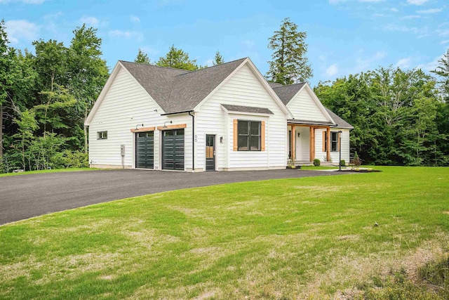 modern farmhouse featuring a garage and a front lawn