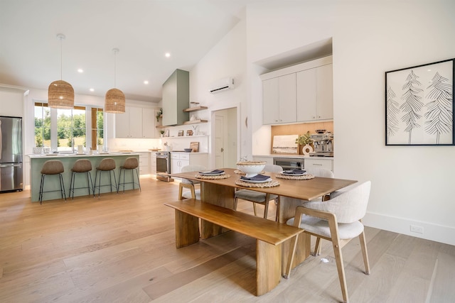 dining space with a wall mounted AC and light wood-type flooring