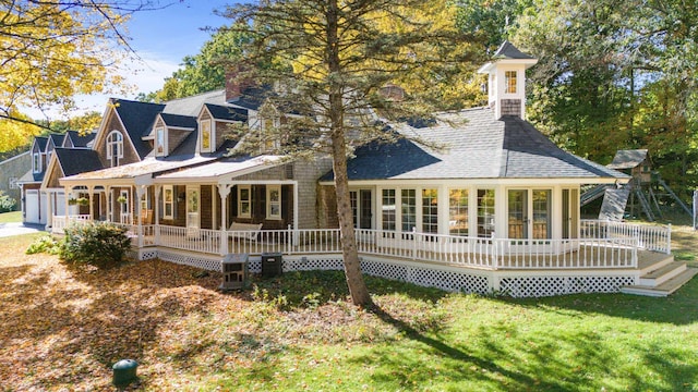 back of property featuring a yard and a shingled roof