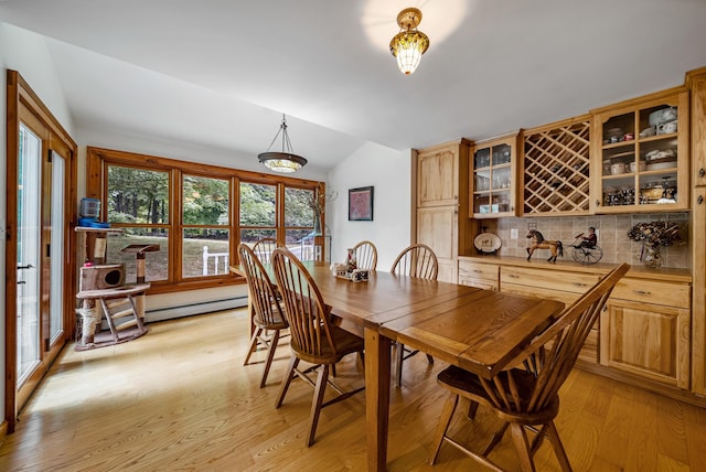 dining area featuring vaulted ceiling and light wood-style flooring