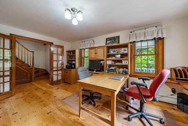 office area with light wood-type flooring, a baseboard radiator, and french doors