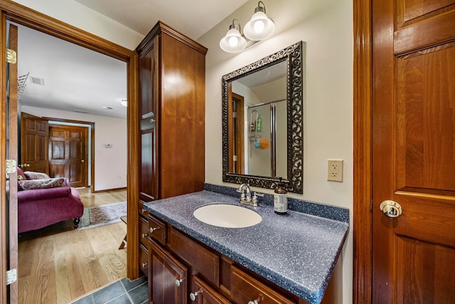 full bathroom featuring wood finished floors, visible vents, vanity, and an enclosed shower