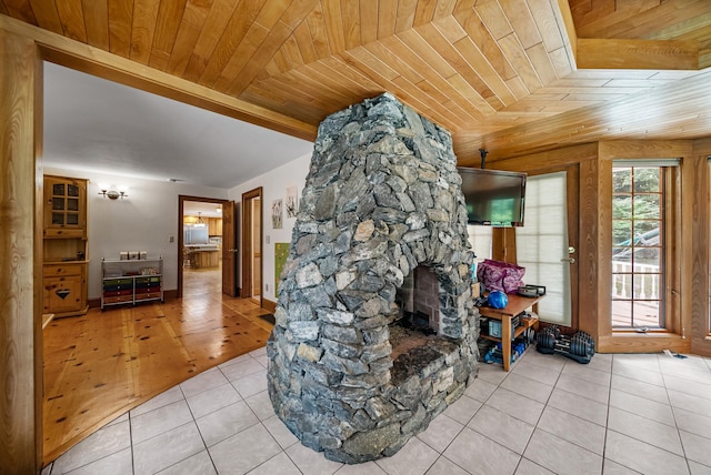 interior space featuring a stone fireplace and wood ceiling