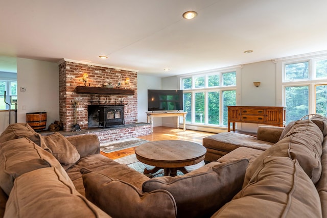 living room featuring light hardwood / wood-style floors, a wood stove, and baseboard heating