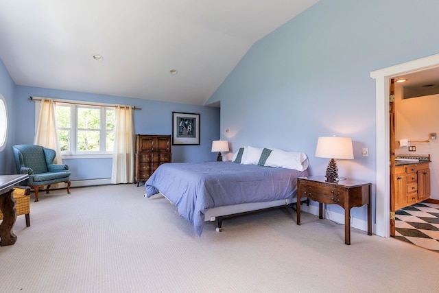 bedroom with ensuite bathroom, lofted ceiling, and light carpet