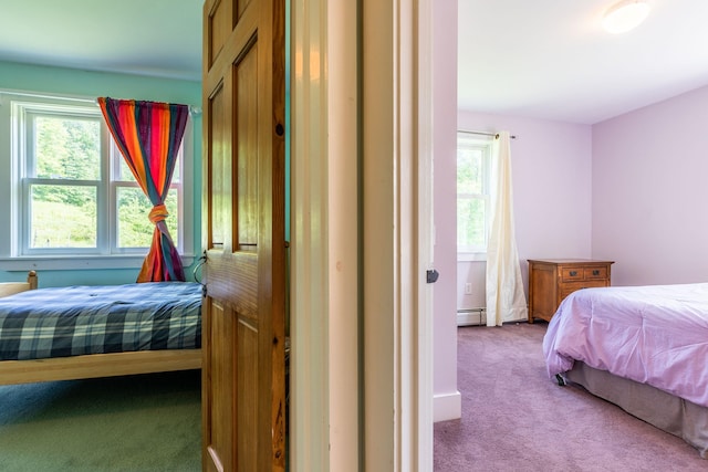 bedroom with carpet, multiple windows, and baseboard heating