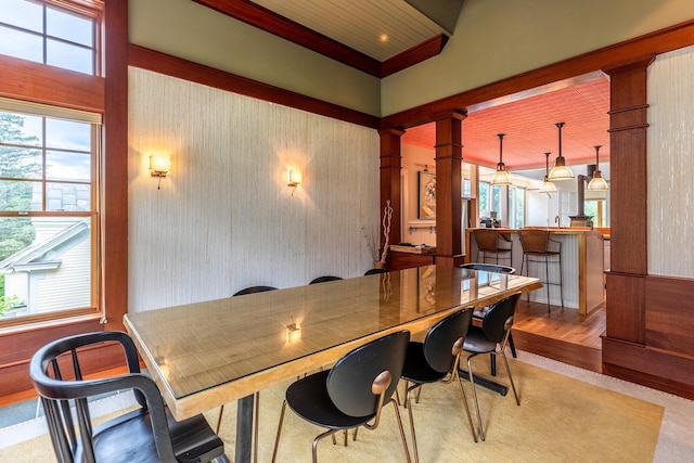 dining area featuring decorative columns and light wood-type flooring