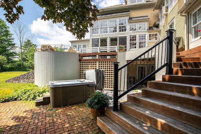 back of house with a hot tub and a patio