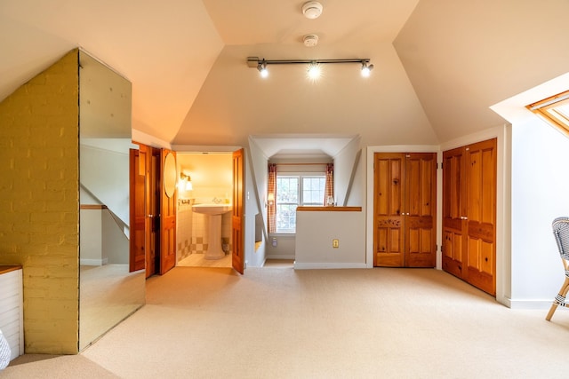 bonus room with vaulted ceiling and carpet floors