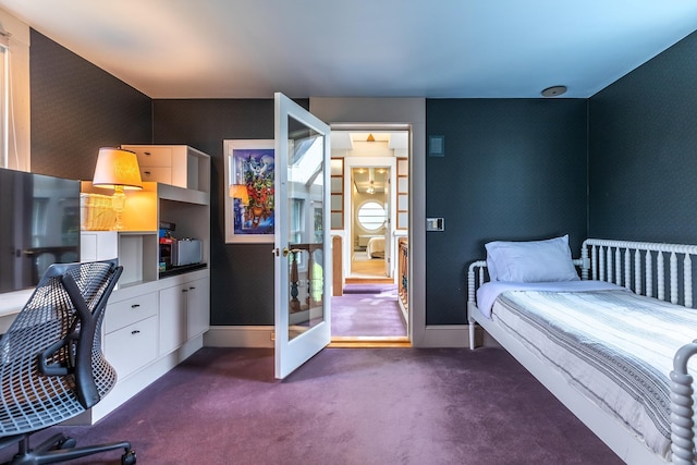 bedroom featuring built in desk and dark carpet