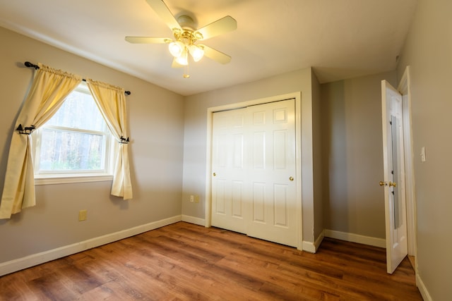 unfurnished bedroom with hardwood / wood-style flooring, ceiling fan, and a closet