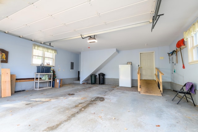 garage with a garage door opener, electric panel, and white refrigerator