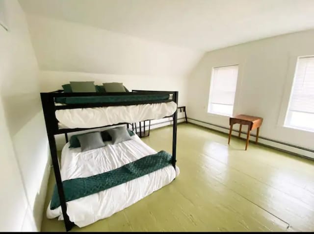 bedroom featuring multiple windows, wood-type flooring, and vaulted ceiling