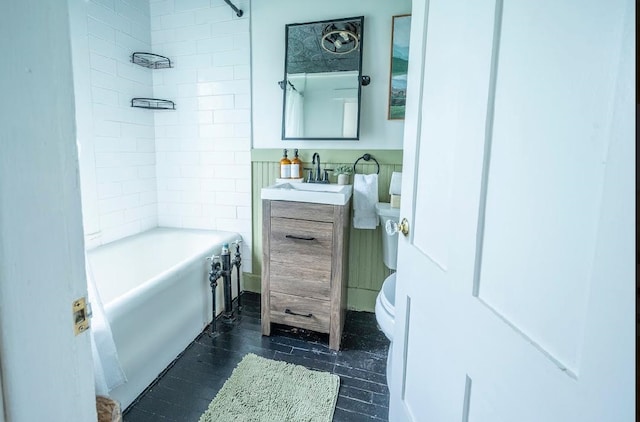 full bathroom featuring vanity, tiled shower / bath combo, and toilet