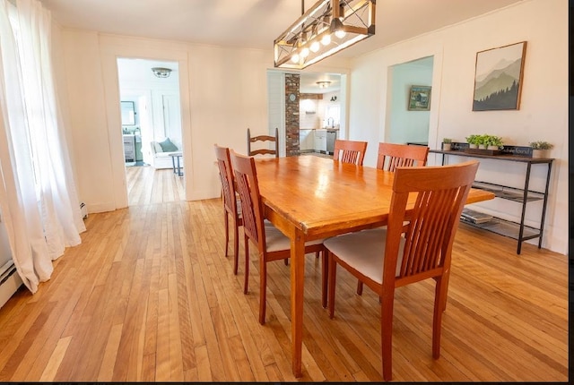 dining room featuring brick wall and light wood-type flooring