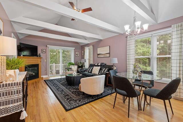 living room with a notable chandelier, lofted ceiling with beams, and hardwood / wood-style floors