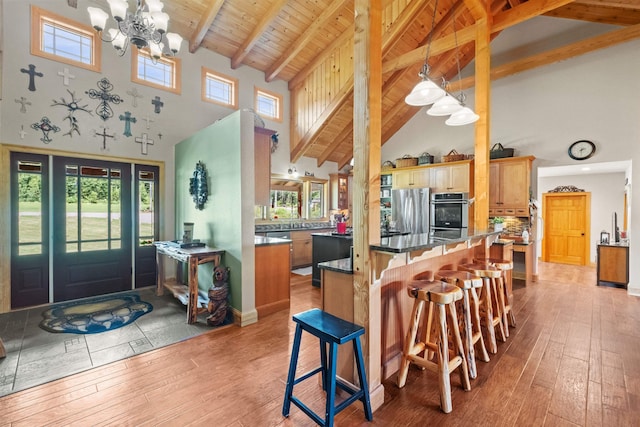 kitchen featuring light wood-type flooring, a kitchen breakfast bar, kitchen peninsula, and appliances with stainless steel finishes