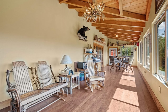 sunroom / solarium featuring lofted ceiling with beams and wood ceiling