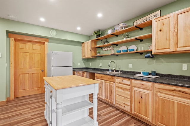 kitchen with wooden counters, light hardwood / wood-style floors, sink, and white fridge