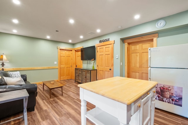 kitchen featuring white refrigerator and hardwood / wood-style floors