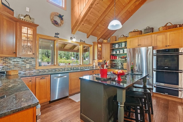 kitchen with stainless steel appliances, plenty of natural light, sink, and beam ceiling