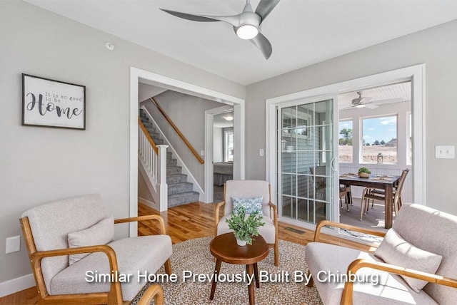 living area with ceiling fan and wood-type flooring