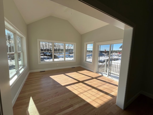 unfurnished sunroom featuring lofted ceiling and visible vents